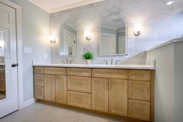 Master bathroom with natural maple double vanity and marble-look tile wall in Raleigh, NC
