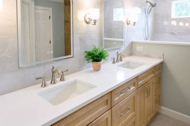 Master bathroom with natural maple double vanity and marble-look tile wall in Raleigh, NC