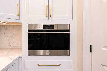 Two-tone kitchen with walnut island and white cabinetry in Cary, NC