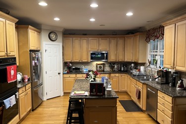 White kitchen with gray island and herringbone tile backsplash in Cary, NC