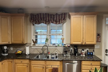 White kitchen with gray island and herringbone tile backsplash in Cary, NC