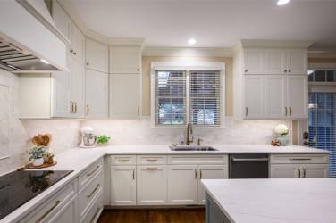White kitchen with gray island and herringbone tile backsplash in Cary, NC