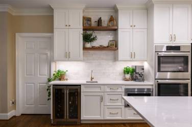White kitchen with gray island and herringbone tile backsplash in Cary, NC