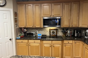 White kitchen with gray island and herringbone tile backsplash in Cary, NC
