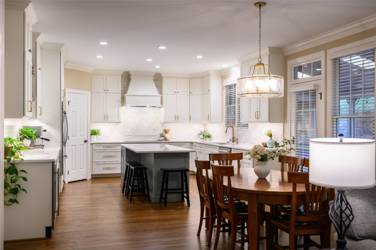 White kitchen with gray island and herringbone tile backsplash in Cary, NC