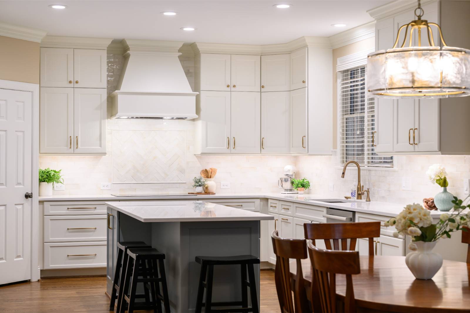 White kitchen with gray island and herringbone tile backsplash in Cary, NC