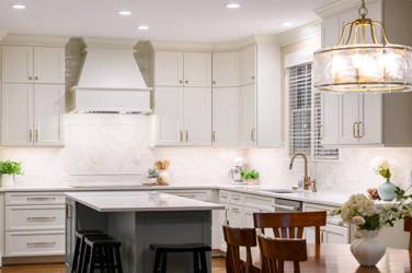 White kitchen with gray island and herringbone tile backsplash in Cary, NC