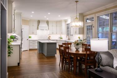 White kitchen with gray island and herringbone tile backsplash in Cary, NC