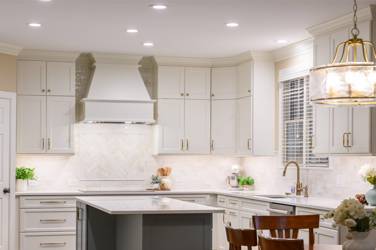 White kitchen with gray island and herringbone tile backsplash in Cary, NC