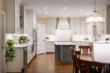 White kitchen with gray island and herringbone tile backsplash in Cary, NC