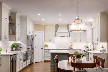 White kitchen with gray island and herringbone tile backsplash in Cary, NC
