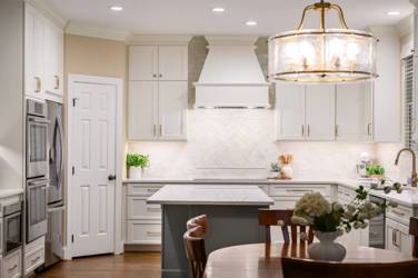 White kitchen with gray island and herringbone tile backsplash in Cary, NC