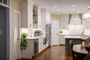 White kitchen with gray island and herringbone tile backsplash in Cary, NC