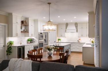 White kitchen with gray island and herringbone tile backsplash in Cary, NC