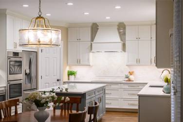 White kitchen with gray island and herringbone tile backsplash in Cary, NC