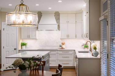 White kitchen with gray island and herringbone tile backsplash in Cary, NC