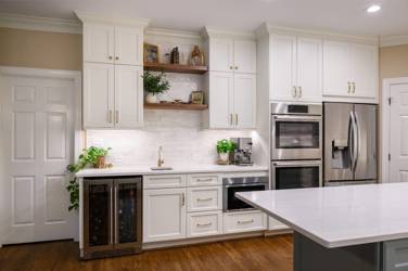 White kitchen with gray island and herringbone tile backsplash in Cary, NC