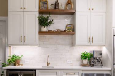 White kitchen with gray island and herringbone tile backsplash in Cary, NC