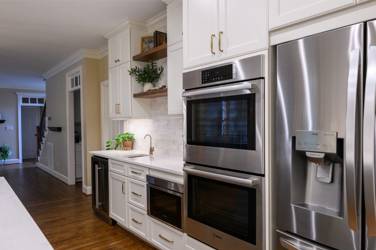 White kitchen with gray island and herringbone tile backsplash in Cary, NC