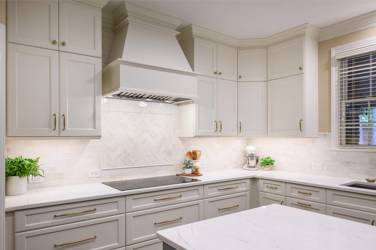 White kitchen with gray island and herringbone tile backsplash in Cary, NC