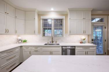 White kitchen with gray island and herringbone tile backsplash in Cary, NC