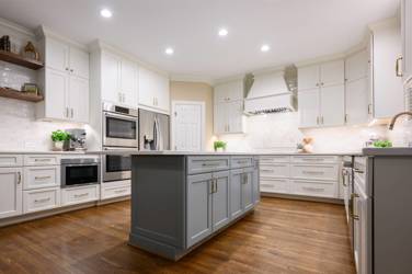 White kitchen with gray island and herringbone tile backsplash in Cary, NC