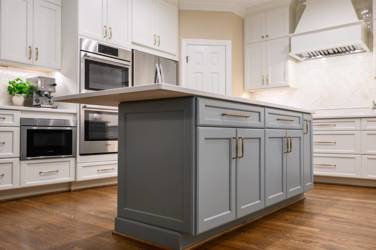White kitchen with gray island and herringbone tile backsplash in Cary, NC