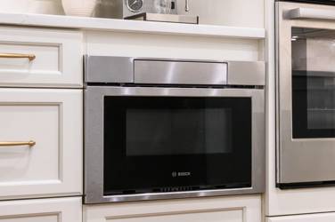 White kitchen with gray island and herringbone tile backsplash in Cary, NC