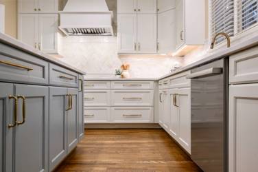 White kitchen with gray island and herringbone tile backsplash in Cary, NC