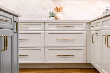 White kitchen with gray island and herringbone tile backsplash in Cary, NC