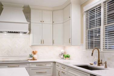 White kitchen with gray island and herringbone tile backsplash in Cary, NC