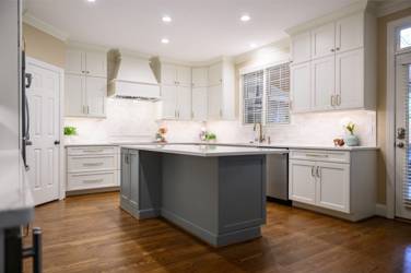 White kitchen with gray island and herringbone tile backsplash in Cary, NC