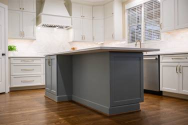 White kitchen with gray island and herringbone tile backsplash in Cary, NC