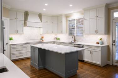 White kitchen with gray island and herringbone tile backsplash in Cary, NC