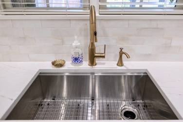 White kitchen with gray island and herringbone tile backsplash in Cary, NC