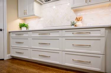 White kitchen with gray island and herringbone tile backsplash in Cary, NC