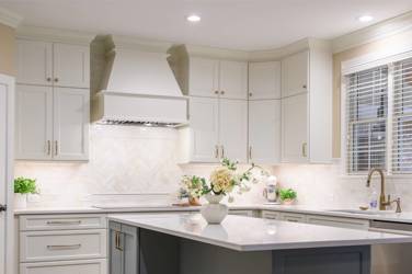 White kitchen with gray island and herringbone tile backsplash in Cary, NC