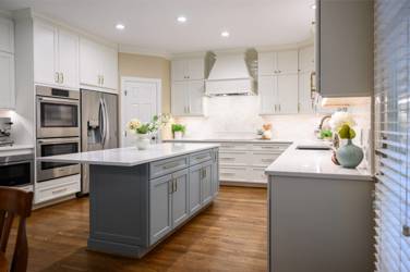 White kitchen with gray island and herringbone tile backsplash in Cary, NC