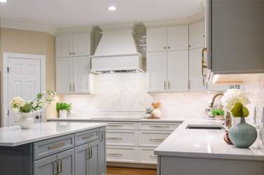 White kitchen with gray island and herringbone tile backsplash in Cary, NC