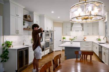 White kitchen with gray island and herringbone tile backsplash in Cary, NC