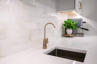 White kitchen with gray island and herringbone tile backsplash in Cary, NC
