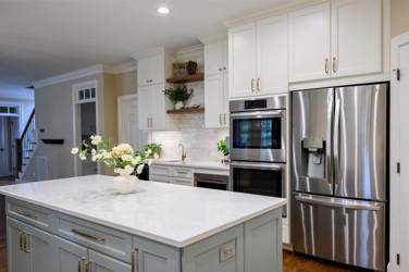 White kitchen with gray island and herringbone tile backsplash in Cary, NC