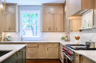 White oak kitchen with sage green island and white quartzite waterfall counters in Raleigh, NC