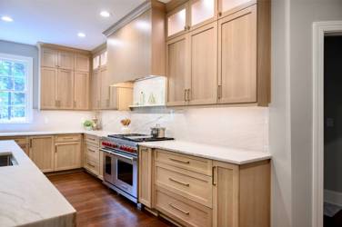 White oak kitchen with sage green island and white quartzite waterfall counters in Raleigh, NC