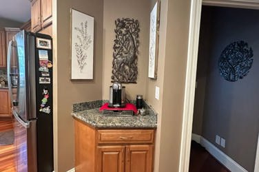 White oak kitchen with sage green island and white quartzite waterfall counters in Raleigh, NC