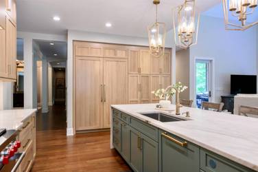 White oak kitchen with sage green island and white quartzite waterfall counters in Raleigh, NC
