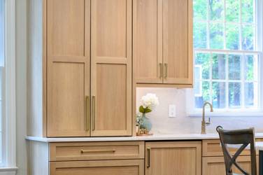 White oak kitchen with sage green island and white quartzite waterfall counters in Raleigh, NC