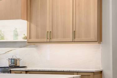 White oak kitchen with sage green island and white quartzite waterfall counters in Raleigh, NC