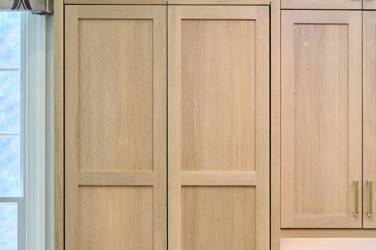 White oak kitchen with sage green island and white quartzite waterfall counters in Raleigh, NC