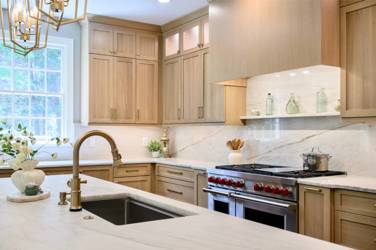 White oak kitchen with sage green island and white quartzite waterfall counters in Raleigh, NC